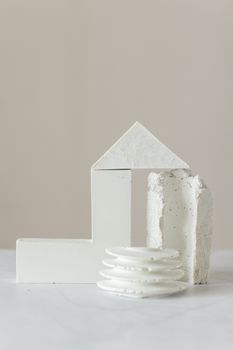 A minimalist arrangement of geometric white shapes on a neutral background.