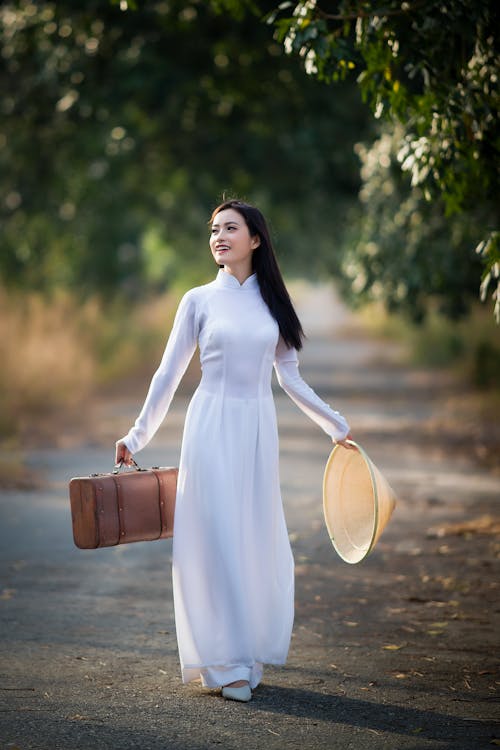 A Woman Holding a Bag and a Conical Hat