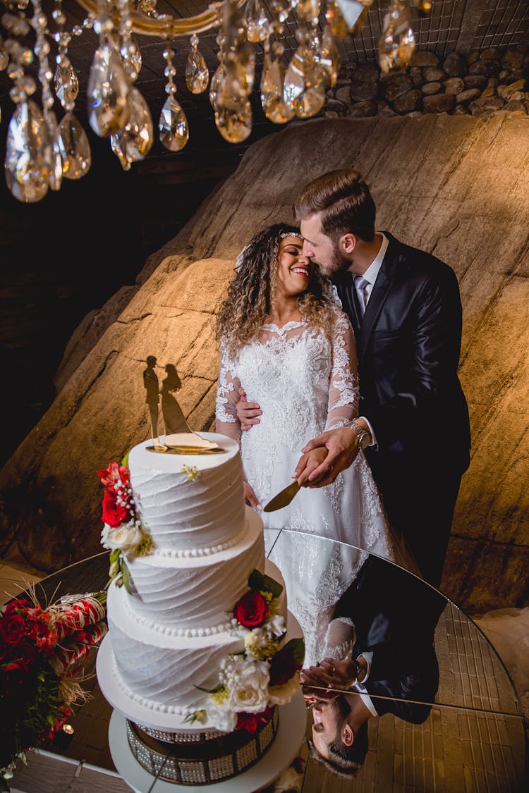 A Bride Ang Groom Slicing A Cake