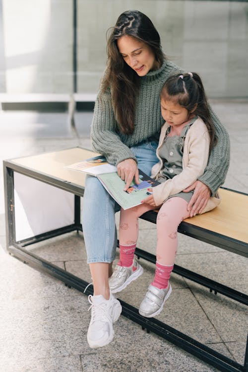 A Mother Reading a Braille Book with Her Daughter