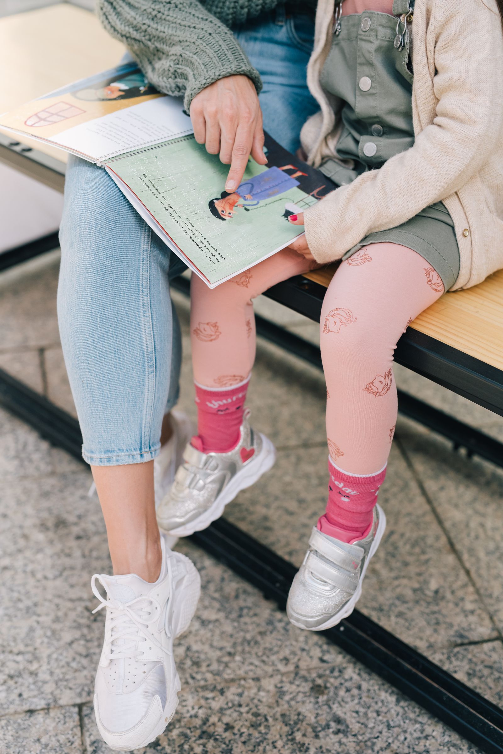 A child and caregiver sharing a bright table activity with drawing materials and hands-on learning tools