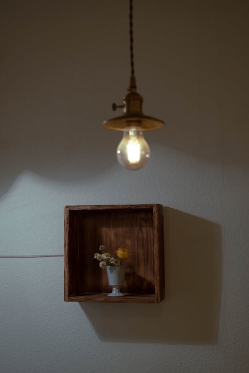 Retro Style Lamp and a Bouquet in a Vase on a Shelf