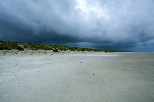 A desolate beach with dramatic storm clouds overhead, capturing the raw beauty of nature.