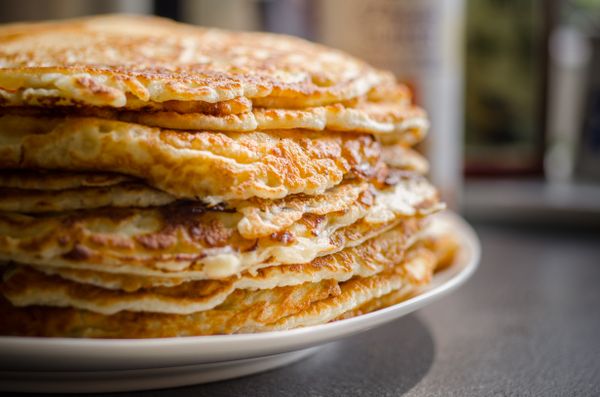 Tall stack of pancakes on a white plate, photo by ClickerHappy on Pexels
