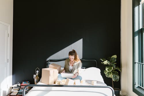 Free A Woman Using a Laptop while in Bed Stock Photo