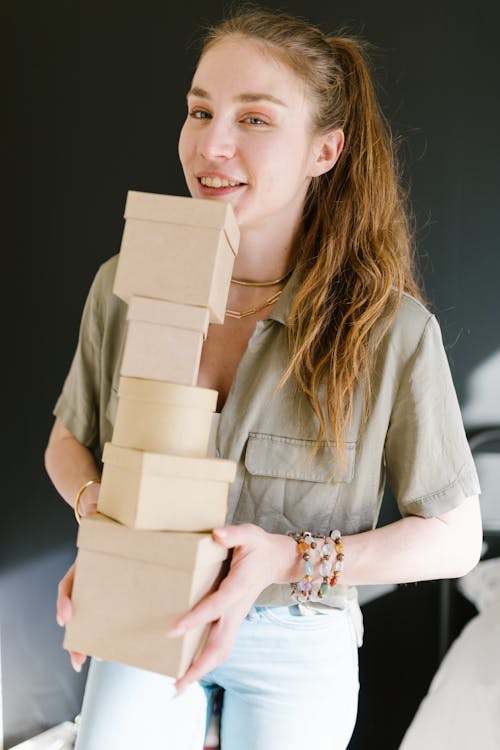 A Young Woman Holding a Pile Cardboard Boxes