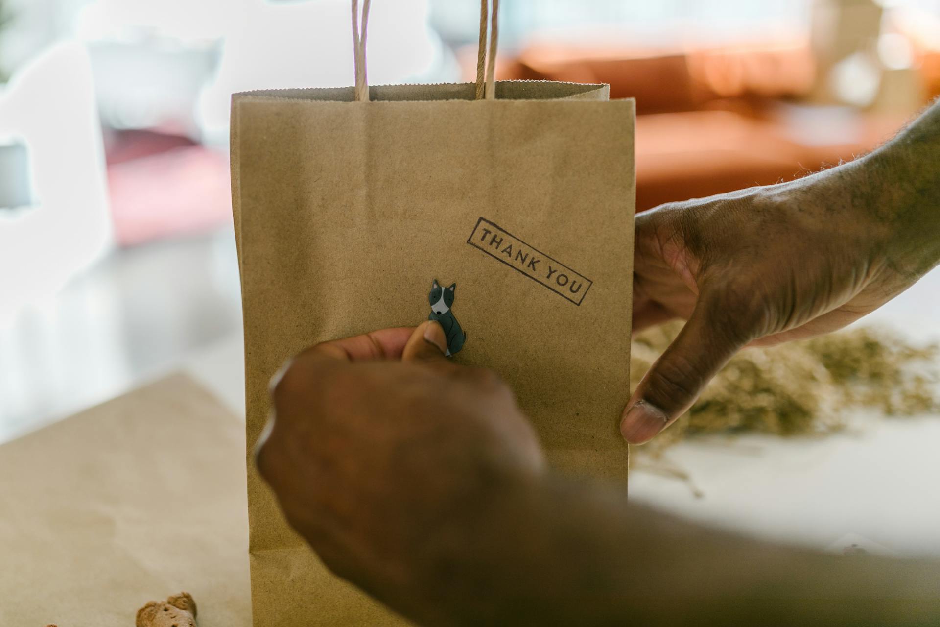 Person Putting a Dog Sticker on Paper Bag