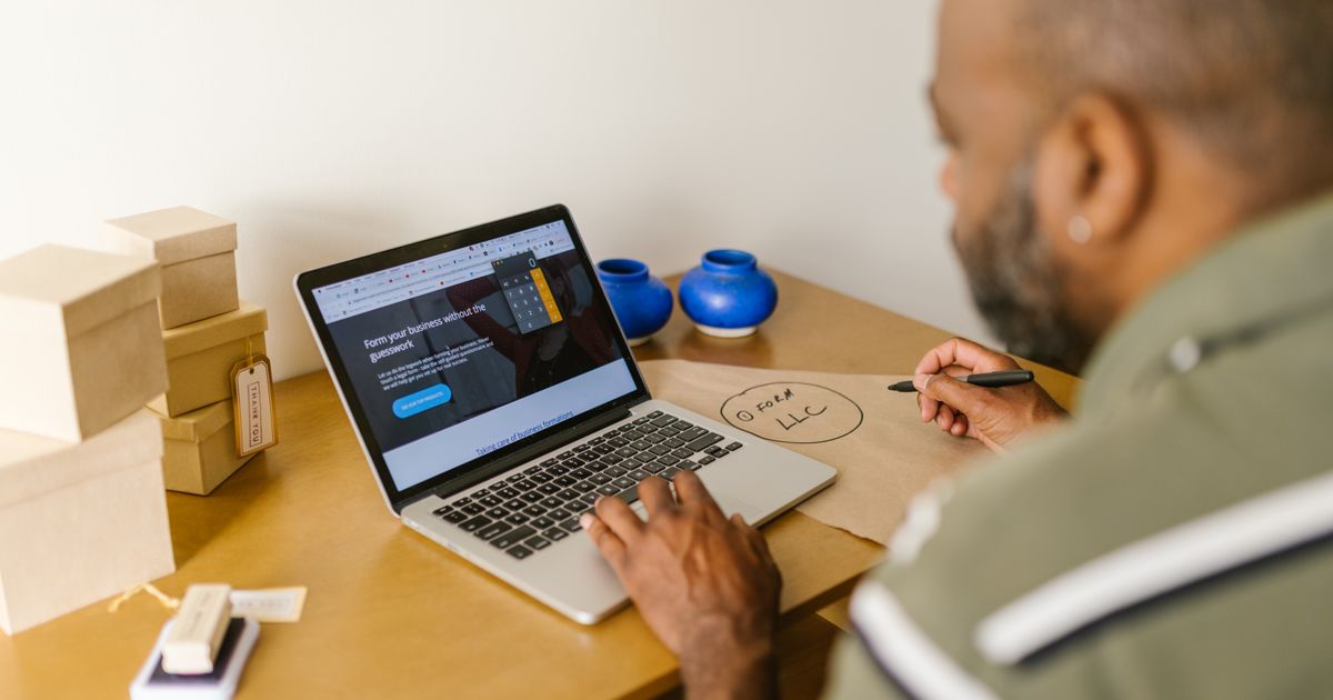 An entrepreneur at a desk using a laptop for business planning.