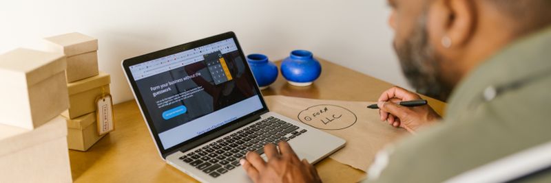 Entrepreneur at a desk using a laptop for business planning. Ideal for tech and startup themes.