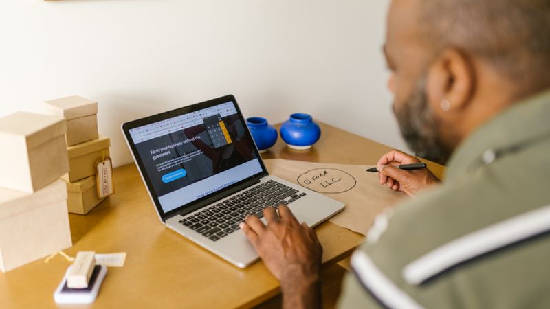 Entrepreneur at a desk using a laptop for business planning. Ideal for tech and startup themes.