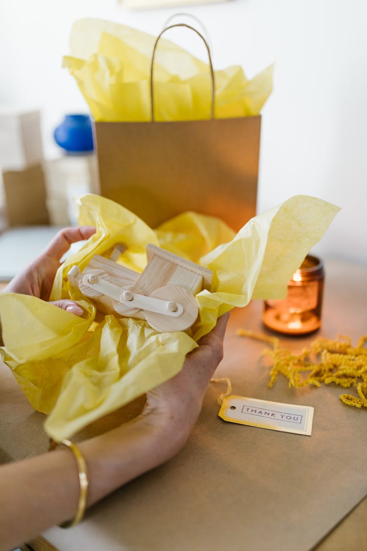 A Close-Up Shot Of A Person Packing A Wooden Toy