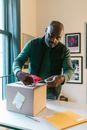 Man in Green Sweater Holding White Paper