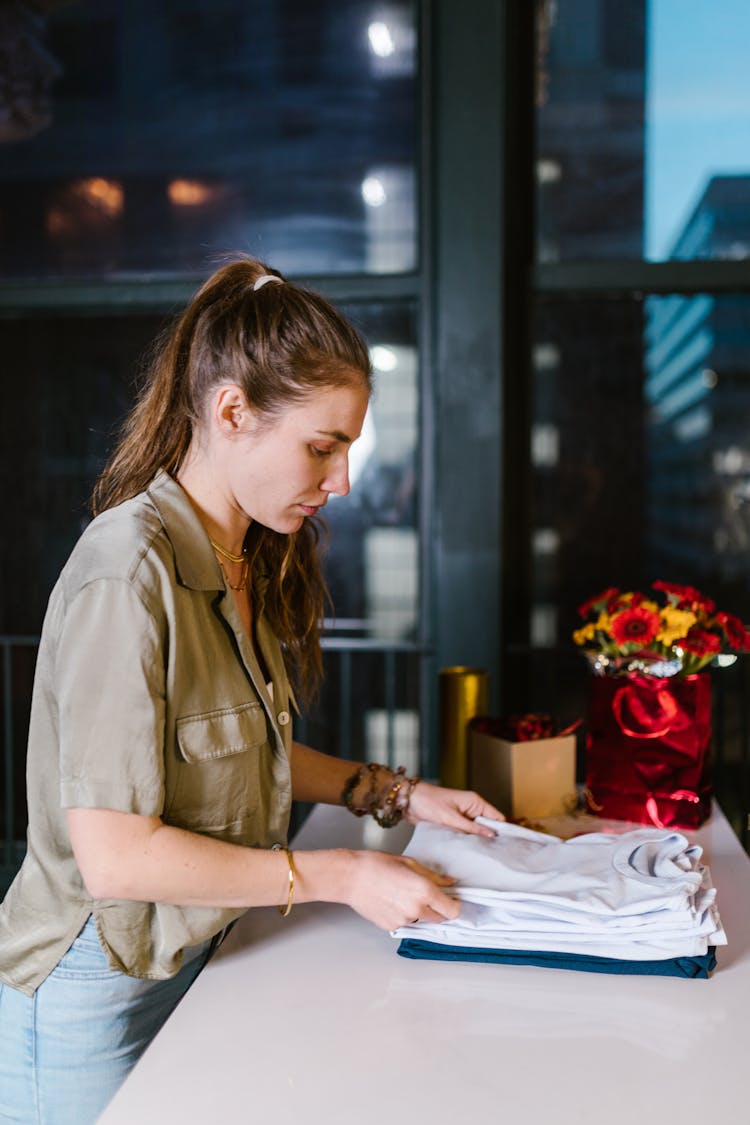 A Woman Neatly Folding Shirts 