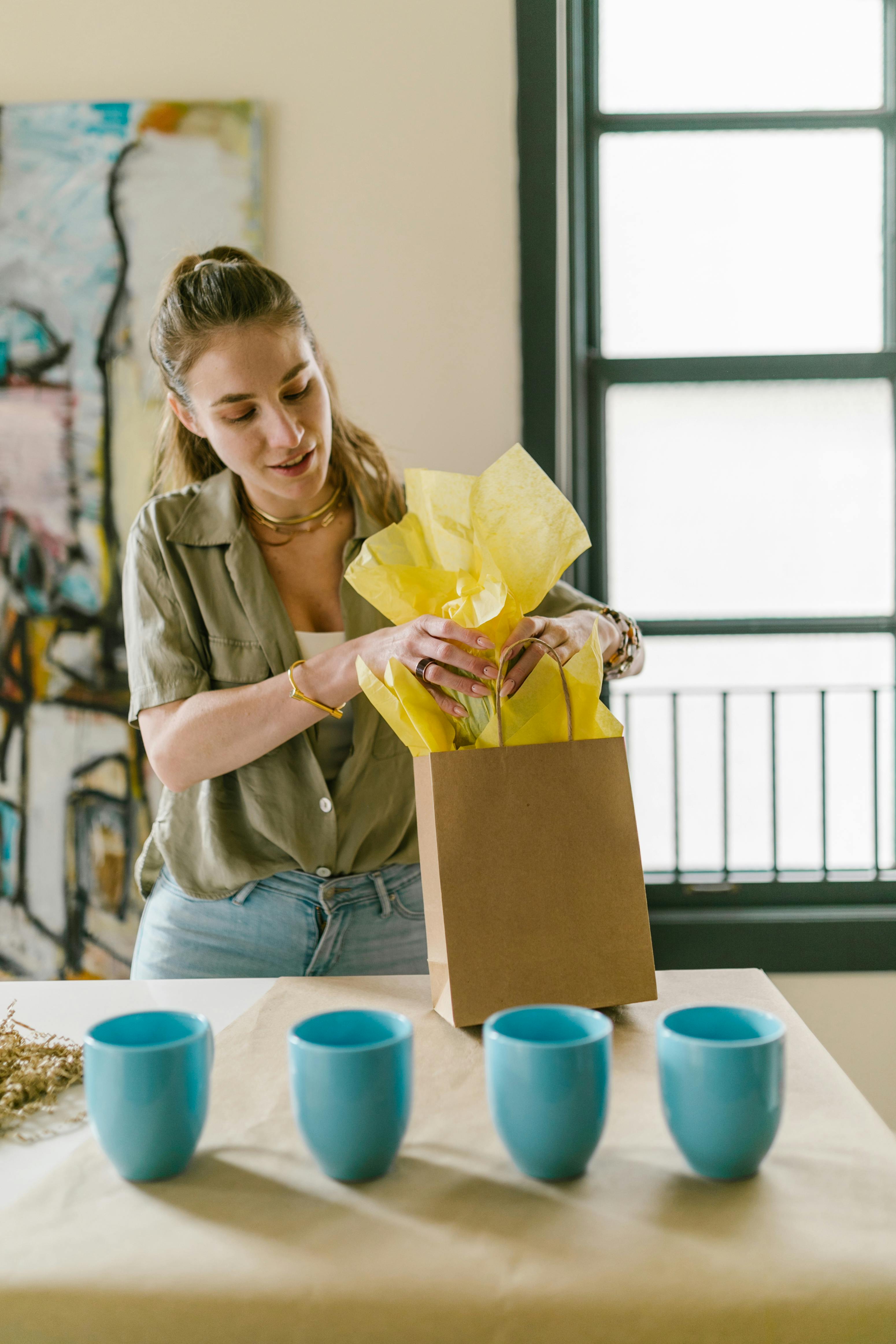 woman packing cup into paper bag