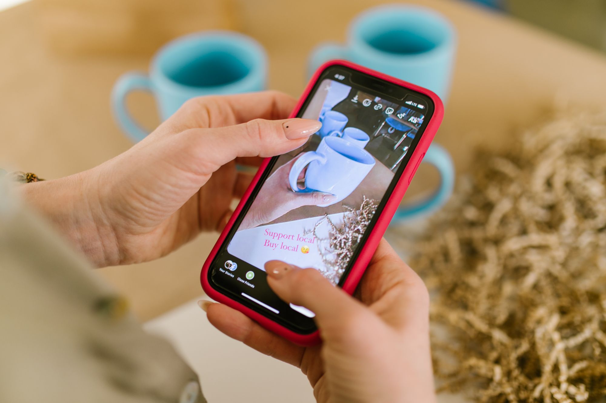 Persona sostiene un teléfono móvil con una aplicación de redes sociales abierta
