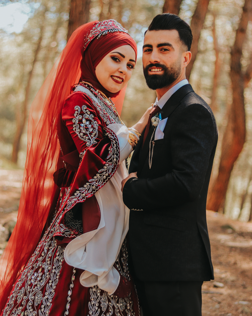 Free Beautiful outdoor photo of a Muslim couple in wedding attire, embracing joyfully. Stock Photo