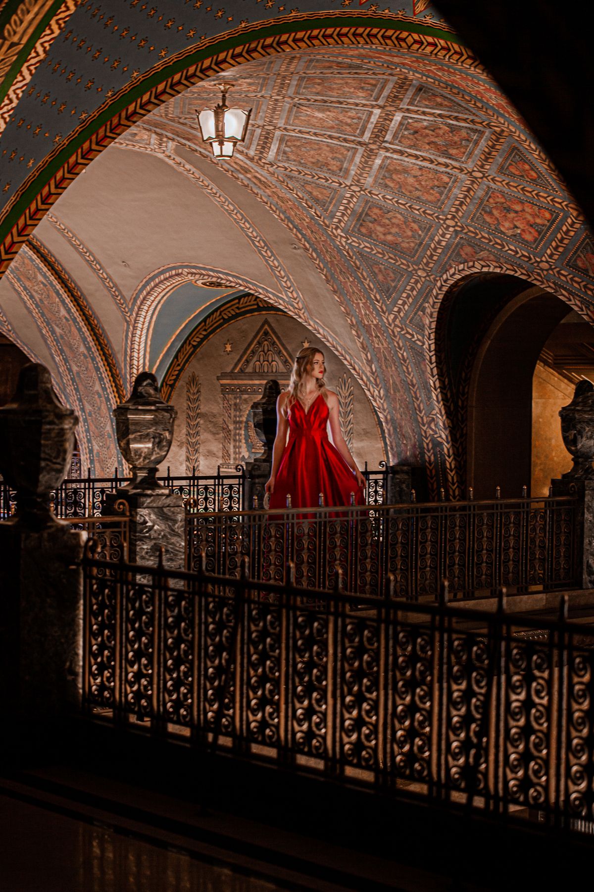 Woman in a dramatic red gown inside an ornate interior
