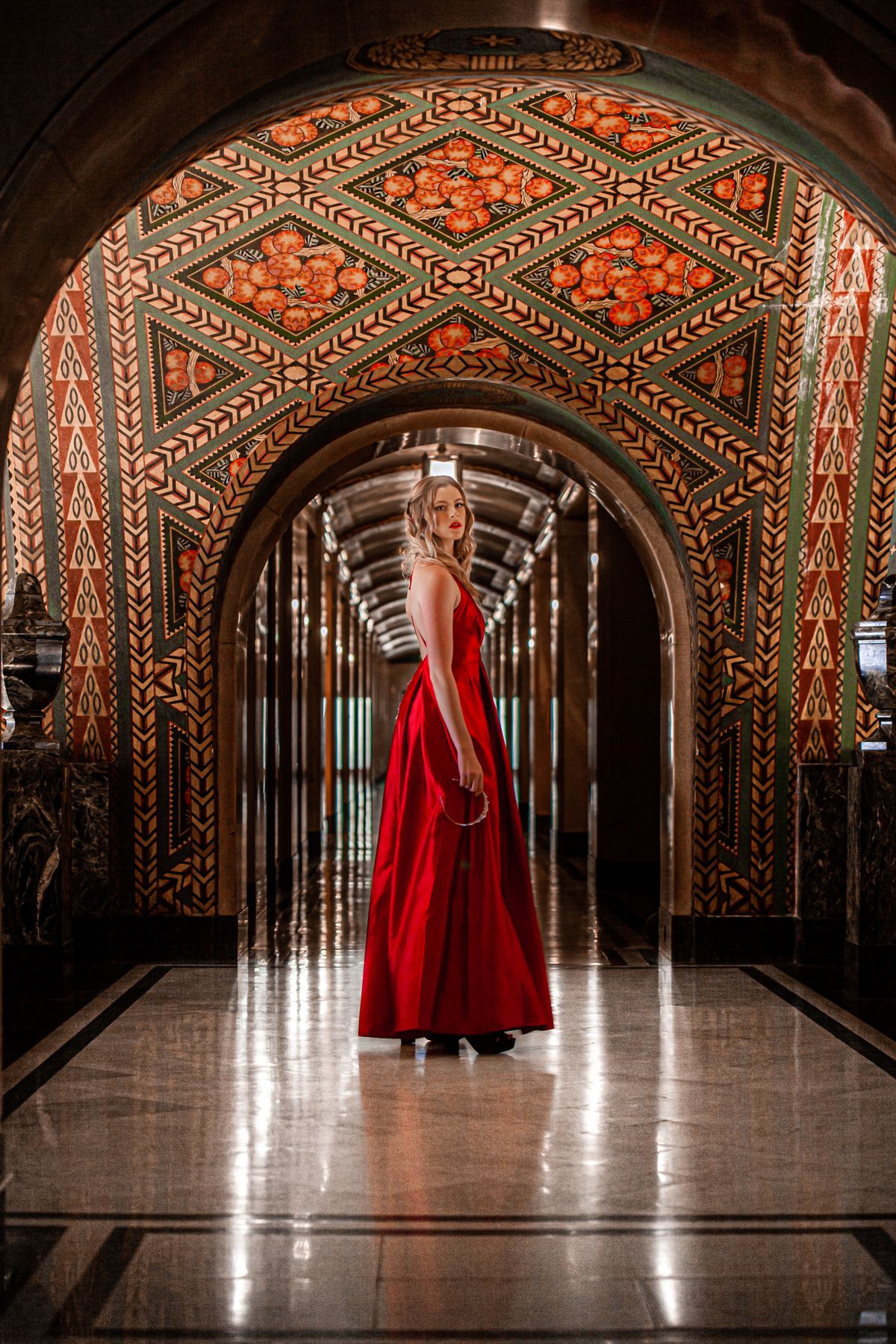 Woman in a red dress in an ornate Art Deco hallway