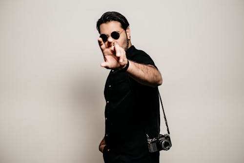 Man in Sunglasses with a Camera Hung Over His Shoulder 