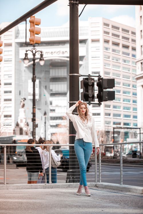 Woman posing confidently on city street, professional street style