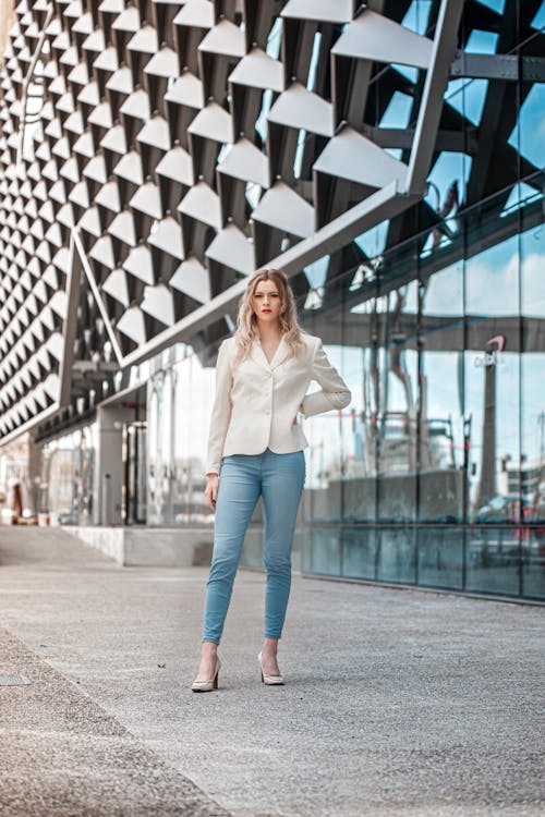 Free A Woman Wearing White Long Sleeves and Denim Jeans Stock Photo