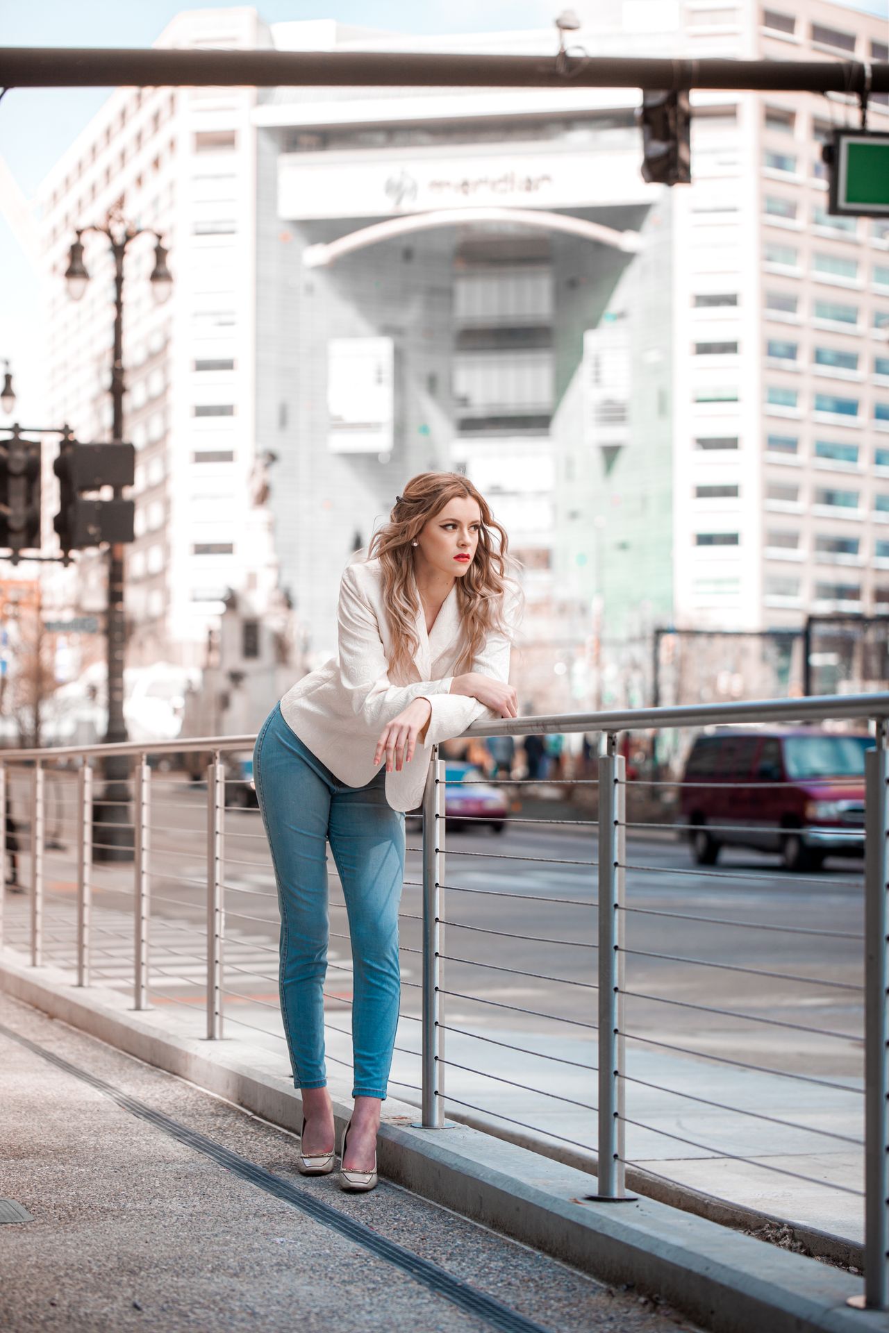 Woman in a white blazer and jeans on a city street