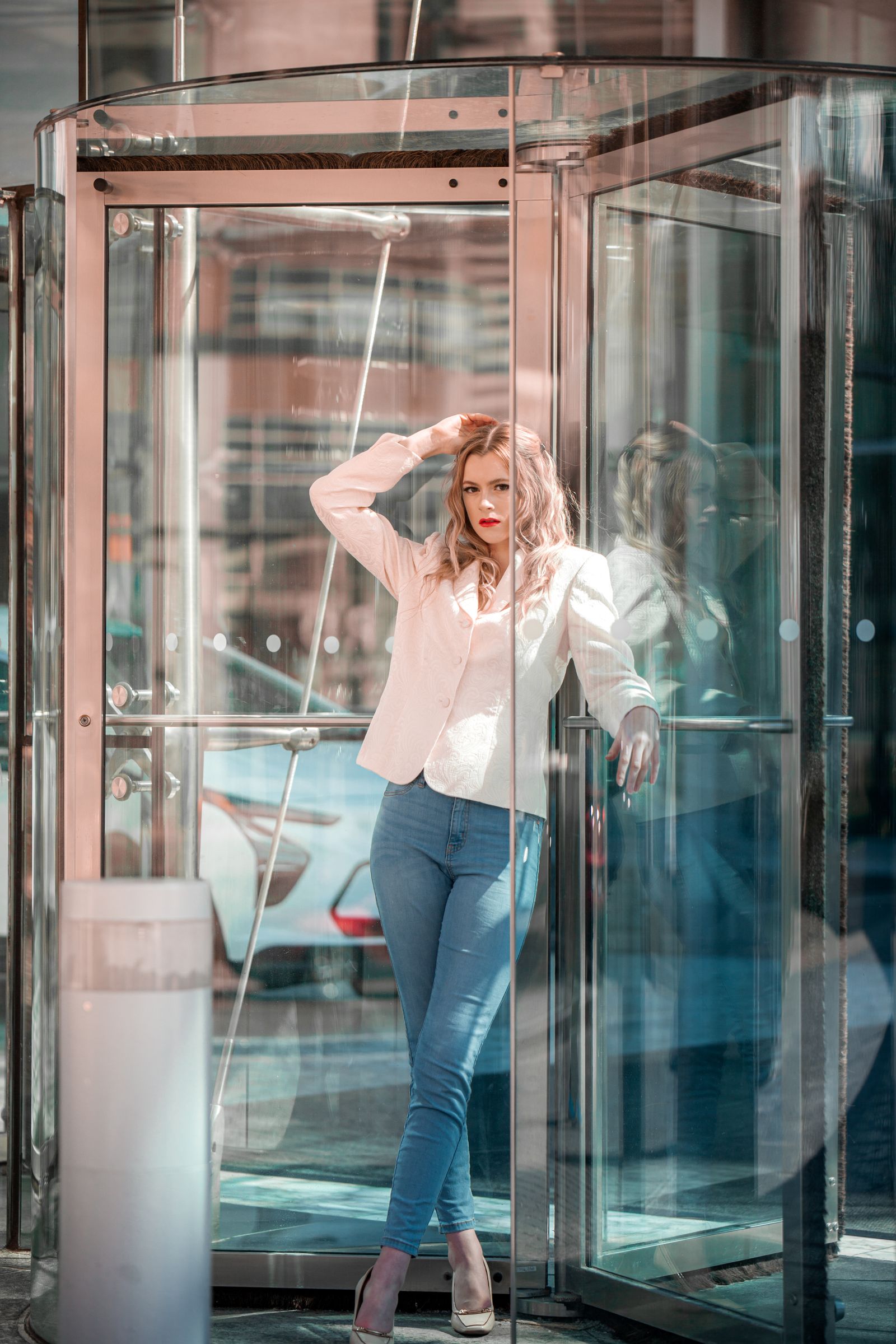 A businesswoman mid-step inside a revolving glass door