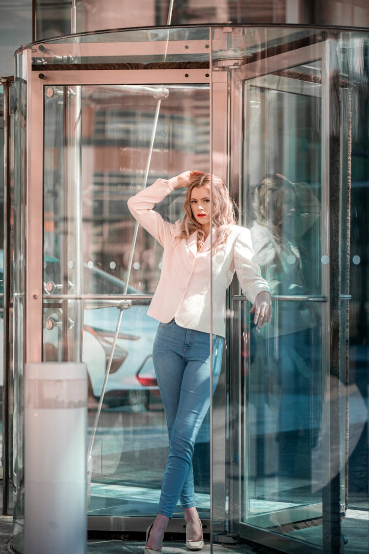 A Woman Standing In A Revolving Glass Door