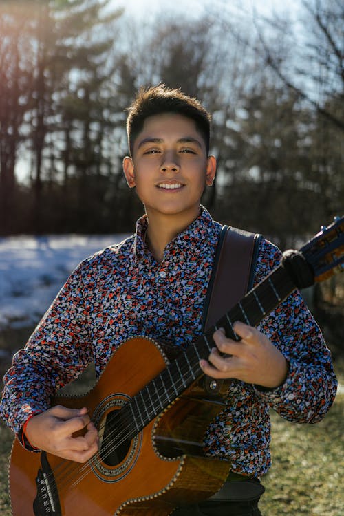 Free Selective Focus of a Boy Holding Acoustic Guitar Stock Photo