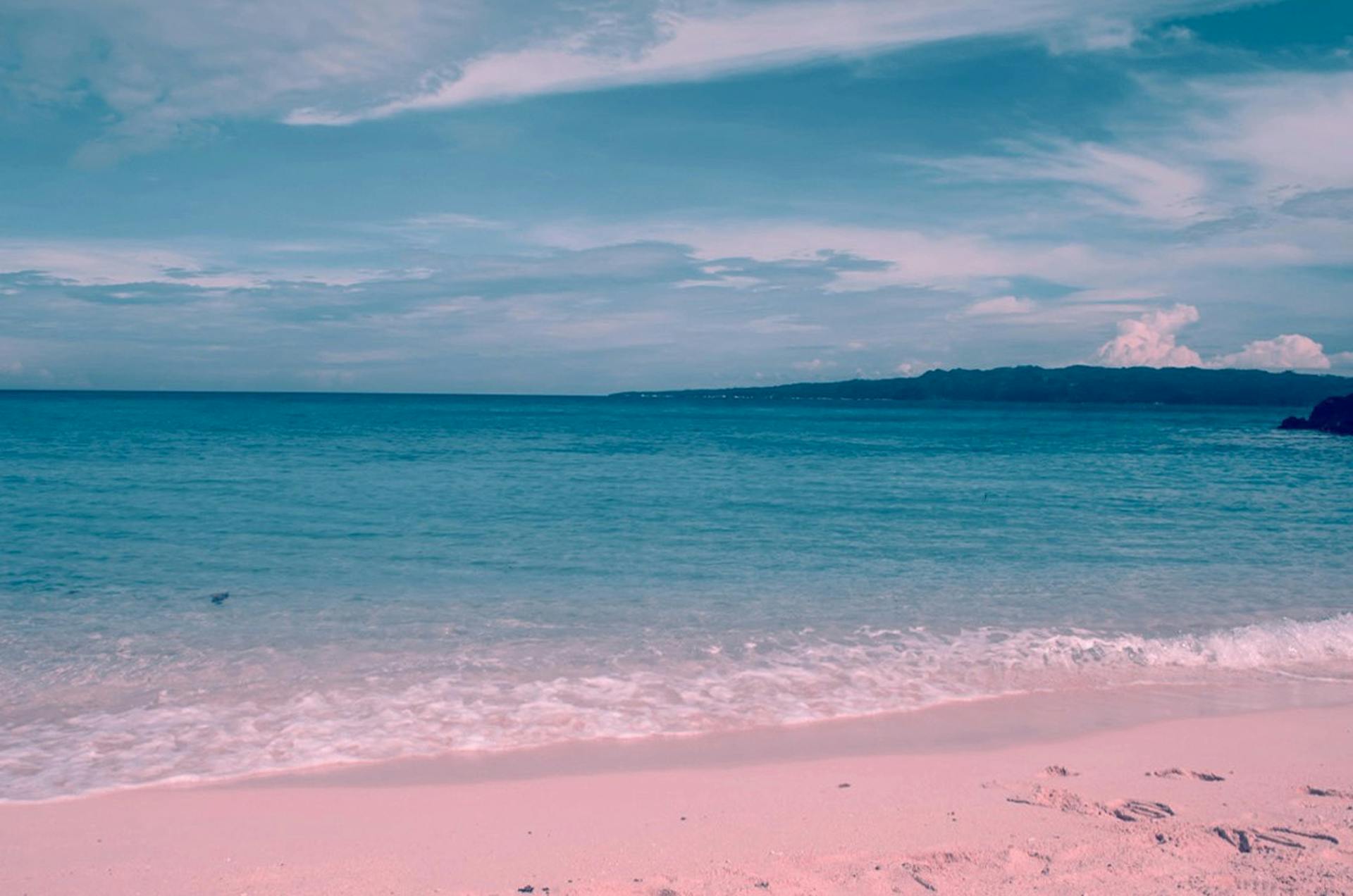 Tranquil beach scene in Malay, Philippines with clear skies and calm ocean waves.