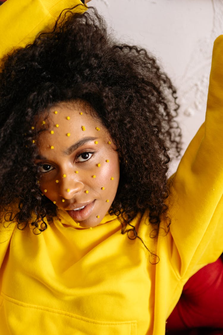 A Woman In Yellow Sweater With Yellow Dots On Face