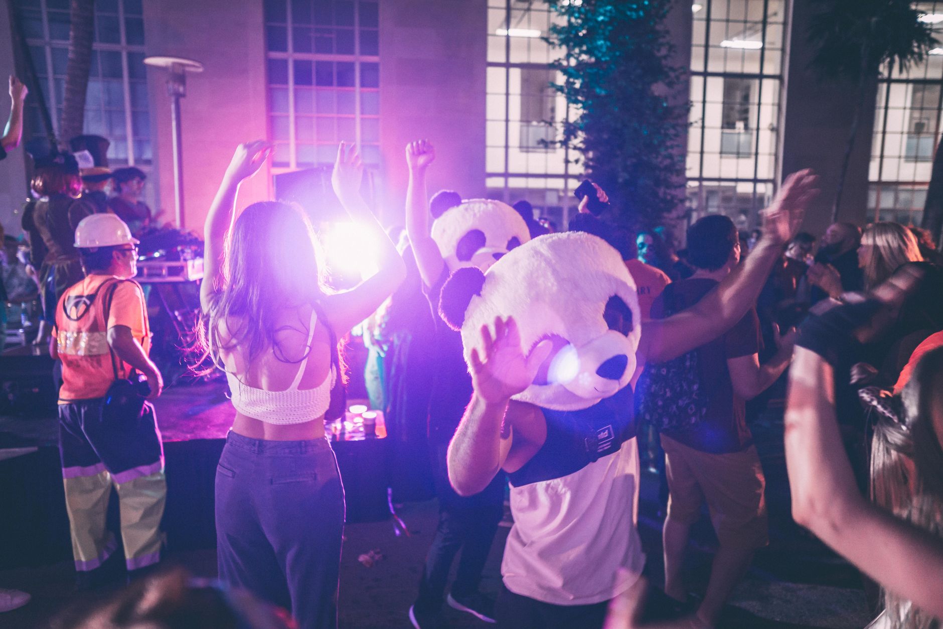 Vibrant night party in Miami Beach with dancing crowd and panda costumes.