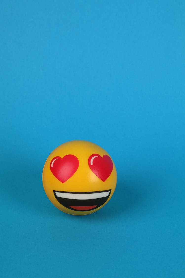 Close-Up Shot Of A Yellow Stress Ball On A Blue Surface