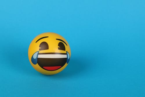 Free A Laughing Emoji with tears over Blue Surface Stock Photo