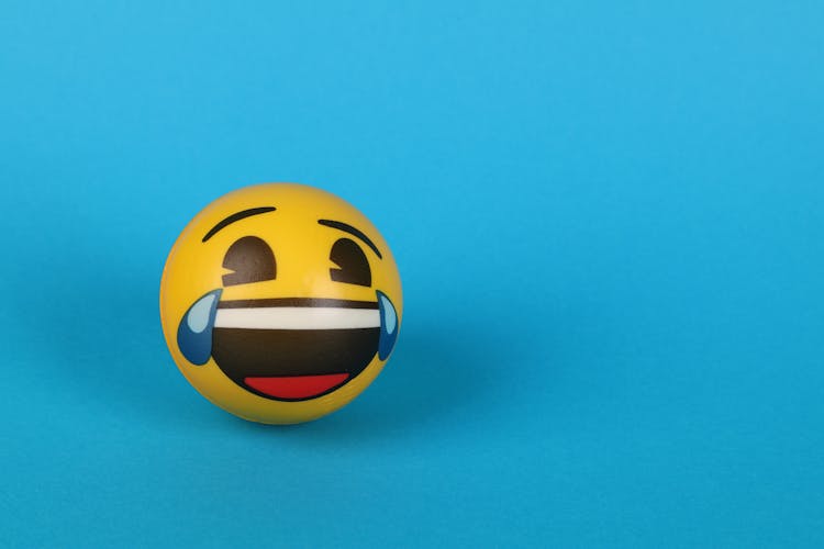 A Laughing Emoji With Tears Over Blue Surface