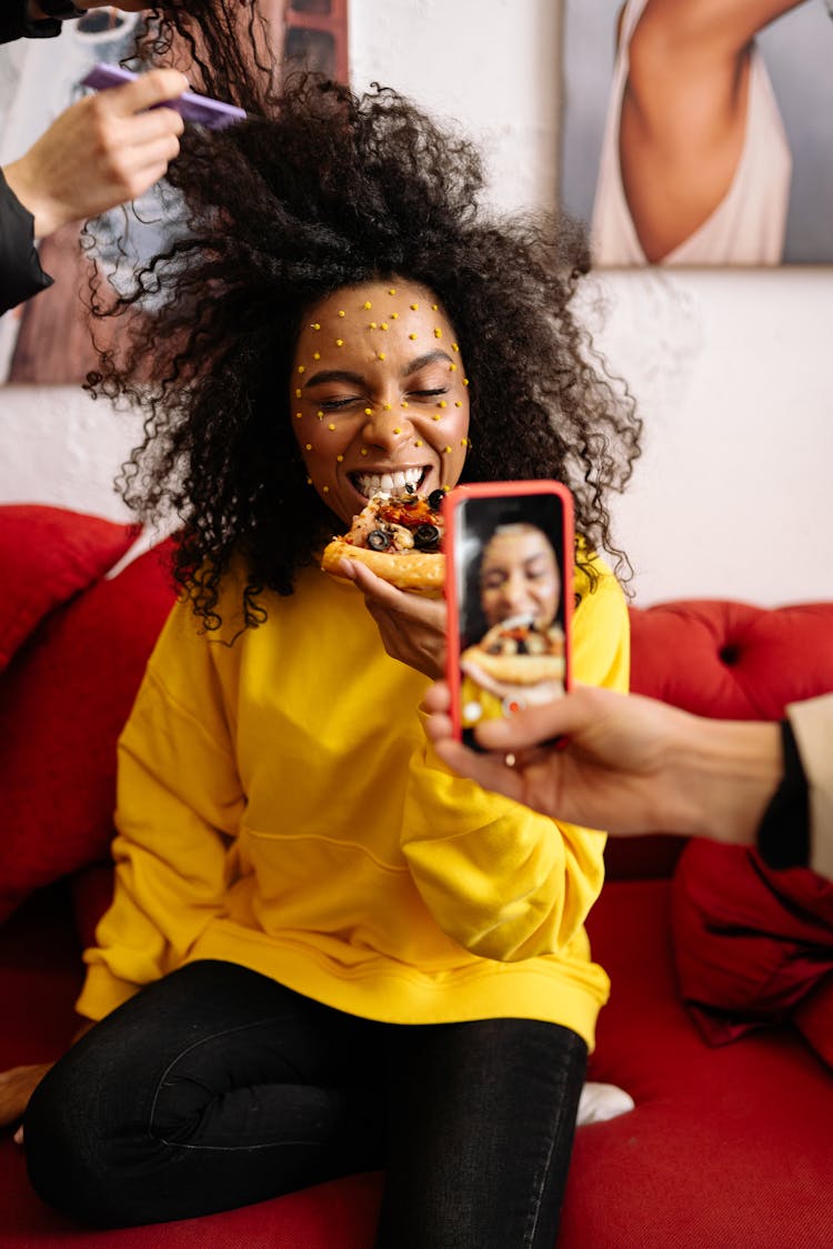 Taking Picture Of Woman Eating Pizza