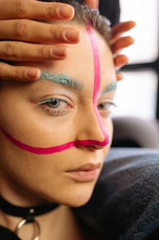 Close-up portrait featuring colorful face paint and artistic makeup, with a focus on expressive eyes.