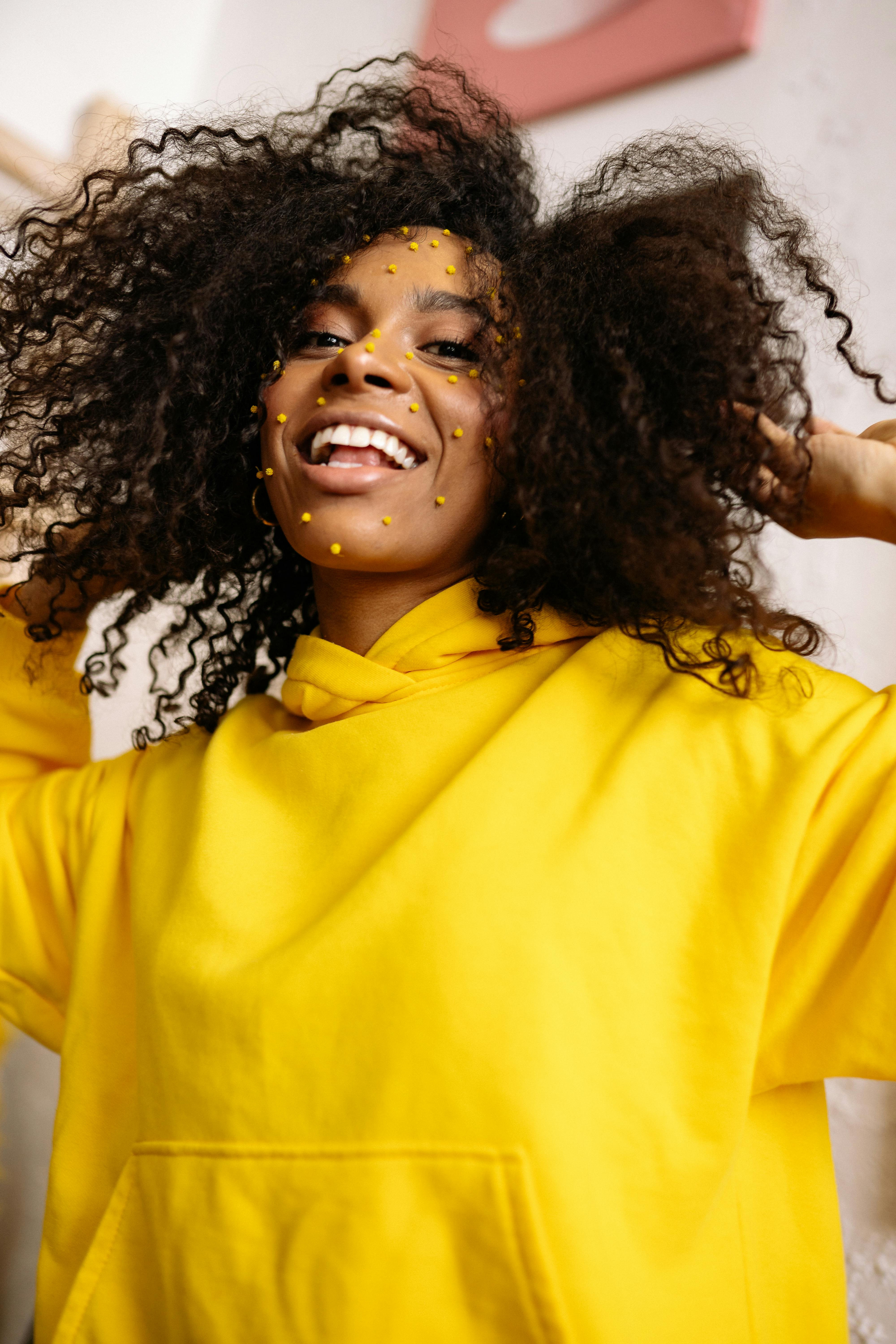 Beautiful black woman with afro curls hairstyleSmiling model in yellow  hoodie Sexy carefree female posing on the street background in sunglasses  Looking at smartphone screen using apps Stock Photo  Adobe Stock