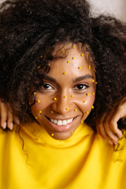 Close Up Photo of Smiling Woman in Yellow Shirt with Polka Dots on Face