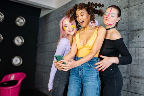Free Fashionable young women express playful styles indoors with bright makeup and hairstyles. Stock Photo