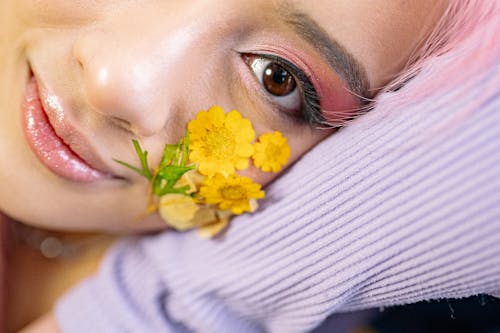 Close-Up Shot of Woman with Yellow Flowers on her Cheek