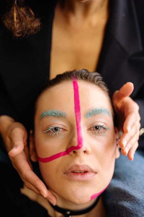 Free Close-up portrait featuring vibrant face paint and unique makeup style. Stock Photo