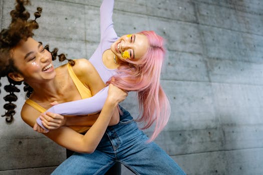 Two young women laughing and posing with creative hairstyles and makeup.