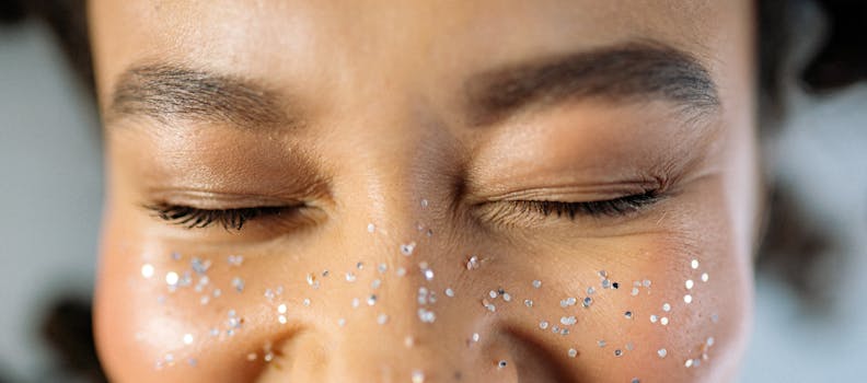 Detailed view of closed eyes adorned with sparkling glitter for a creative makeup look.