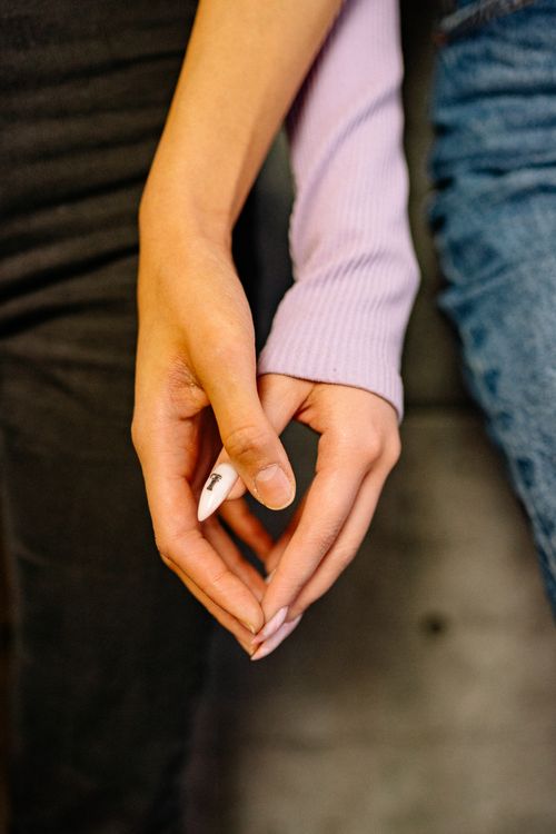 Free A close-up of two people holding hands, showcasing connection and warmth. Stock Photo