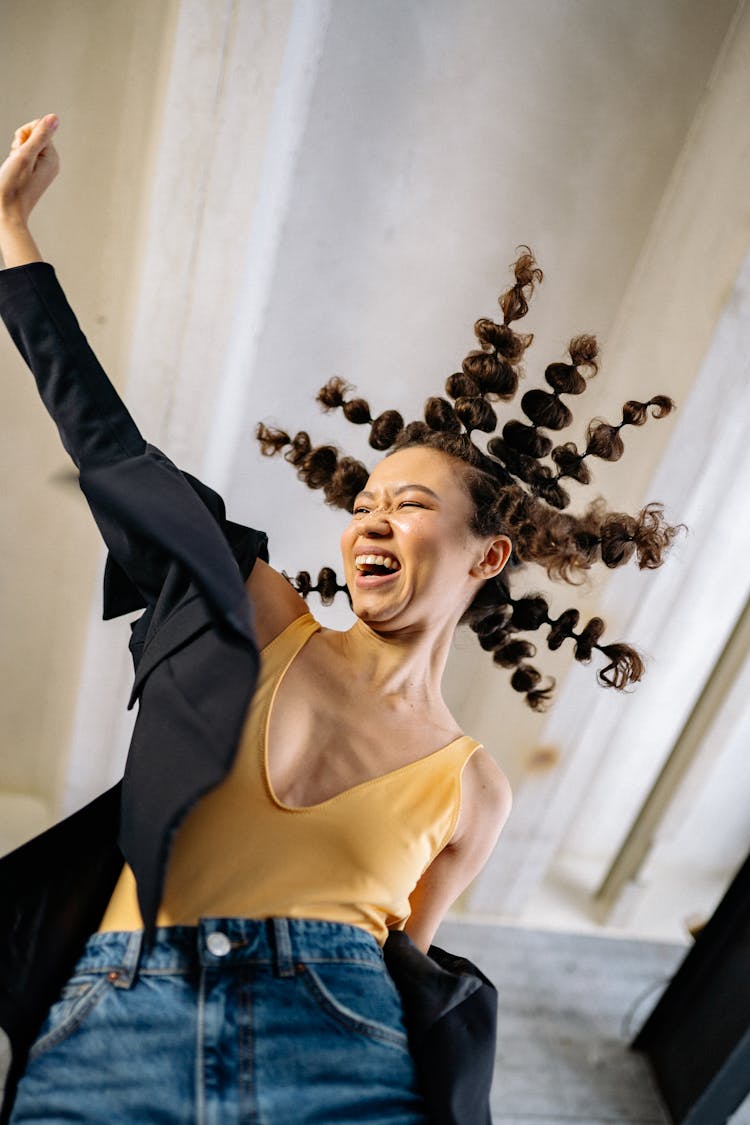 Young Woman With Crazy Hairstyle Laughing And Putting Her Arm Up 