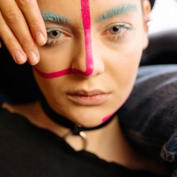 Close-up portrait of a woman with vibrant art makeup and a bold look.