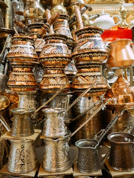 Beautiful display of intricately designed Turkish coffee pots in a vibrant Istanbul market.
