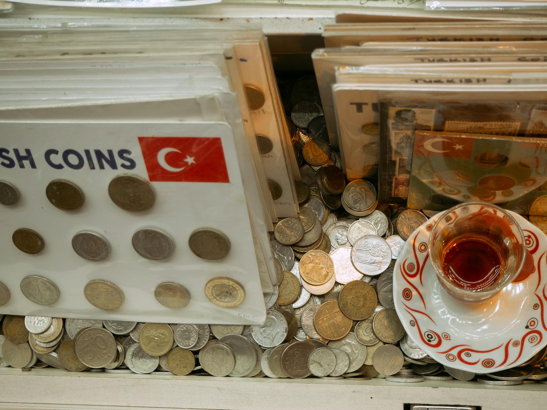 A vibrant display of Turkish coins alongside a traditional tea cup in Istanbul.