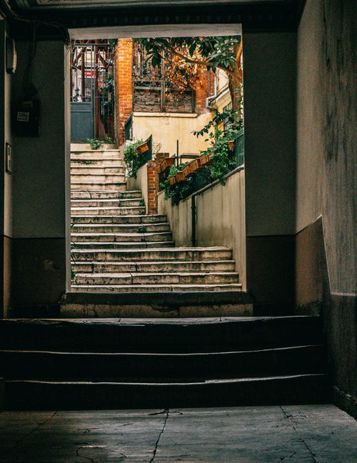 Free Explore a quaint alleyway in Istanbul featuring steps, brick walls, and lush greenery. Stock Photo